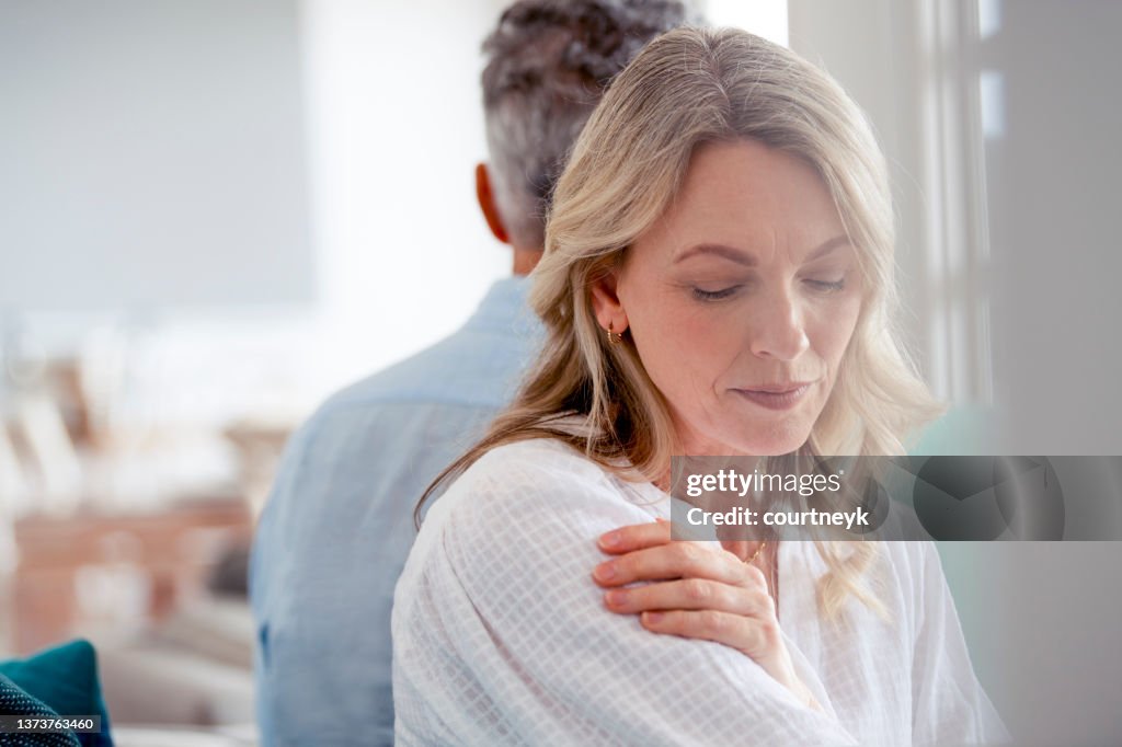 Mature couple fighting at home sitting on the sofa.