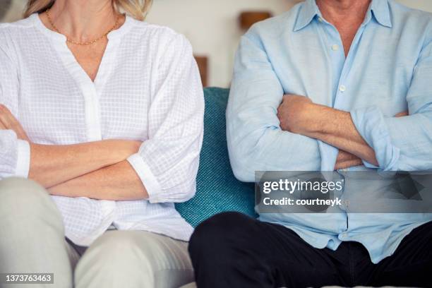 casal maduro brigando em casa sentado no sofá. - sad woman divorce - fotografias e filmes do acervo