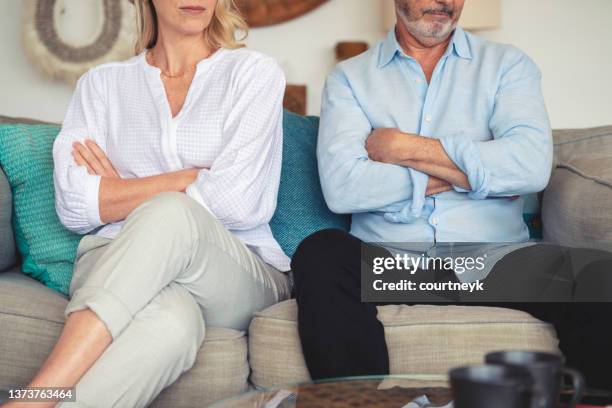 mature couple fighting at home sitting on the sofa - ignoring stock pictures, royalty-free photos & images