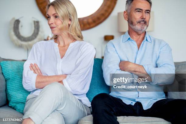 mature couple fighting at home sitting on the sofa - an old mistress stock pictures, royalty-free photos & images