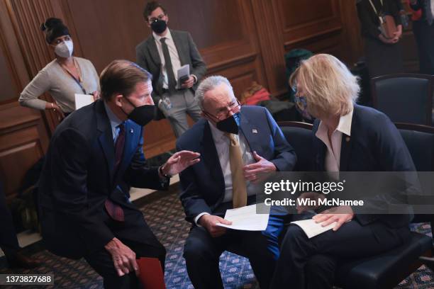 Senate Majority Leader Chuck Schumer confers with Sen. Richard Blumenthal and Sen. Tammy Baldwin before a press conference at the U.S. Capitol...