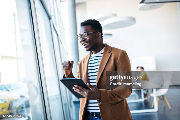 young businessman surfing the net in the modern office - office cheering stock pictures, royalty-free photos & images