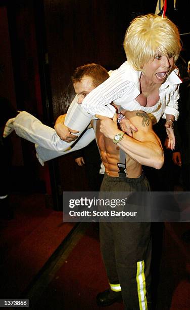 Actress Barbara Windsor is picked up by firefighter Neil Smithers at the Twin Towers celebrity party held at Red Cube September 8, 2002 in London,...