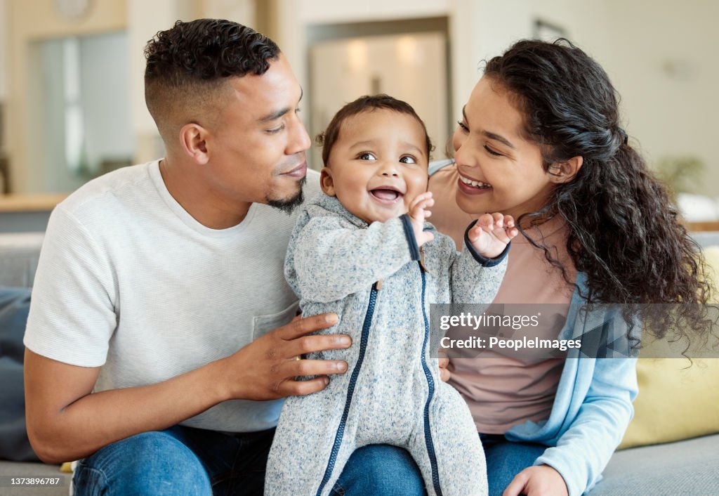 Scatto di una giovane famiglia che si lega al loro bambino a casa