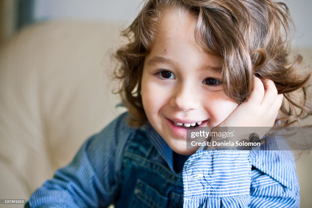 Smiling boy with hand on cheek