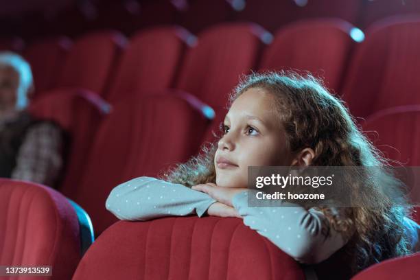 bambina nel cinema che guarda il film - children theatre foto e immagini stock