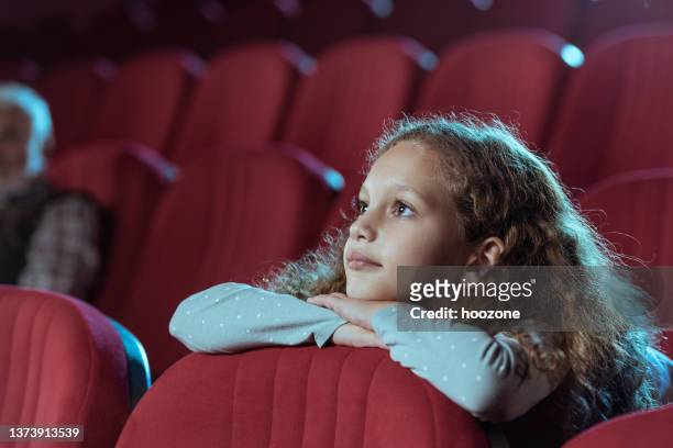 little girl in cinema watching movie - cinema hall stock pictures, royalty-free photos & images