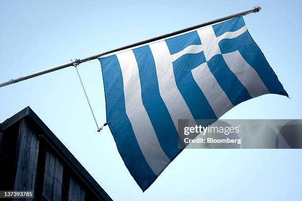 The Greek national flag flies from the Congress Centre, the venue of the World Economic Forum's 2012 annual meeting, in the town of Davos,...