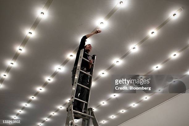 Worker replaces a light bulb inside the Congress Centre, the venue of the World Economic Forum's 2012 annual meeting, in the town of Davos,...