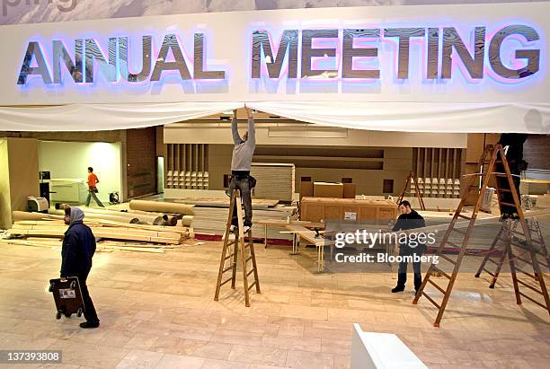 Workers stand on ladders to arrange the interior ceiling decoration inside the Congress Centre, the venue of the World Economic Forum's 2012 annual...