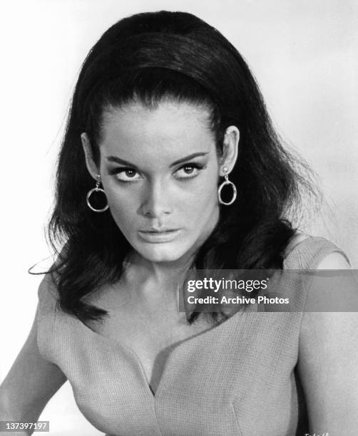 Martine Beswick looking serious wearing circular earrings in a scene from the film 'Thunderball', 1965.