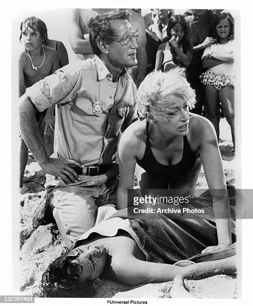 Roy Scheider and Lorraine Gary huddle anxiously over their son Chris Rebello in a scene from the film 'Jaws', 1975.