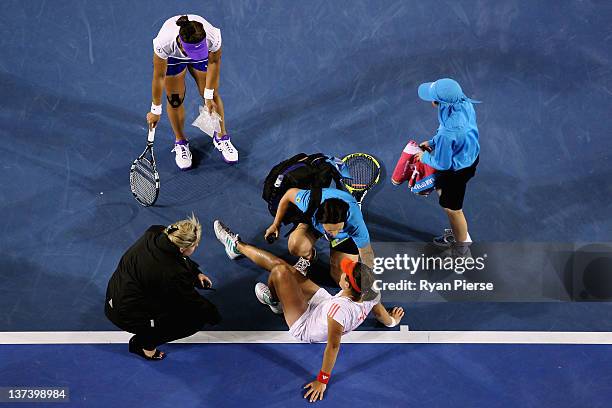 Anabel Medina Garrigues of Spain is attended to by medical staff after injuring her ankle in her third round match against Na Li of China during day...