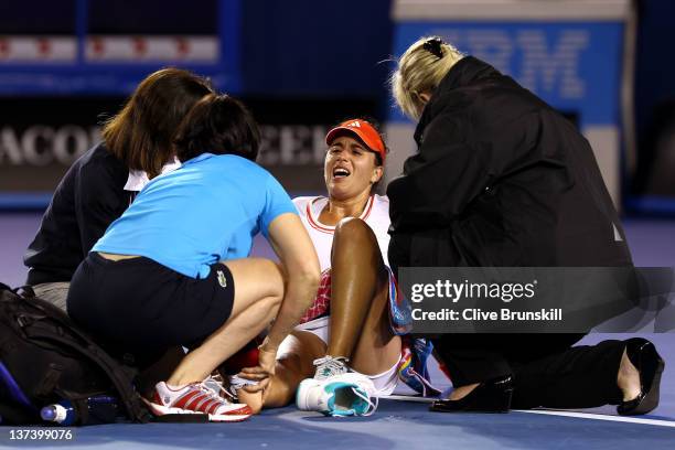 Anabel Medina Garrigues of Spain is attended to by medical staff after injuring her ankle in her third round match against Na Li of China during day...