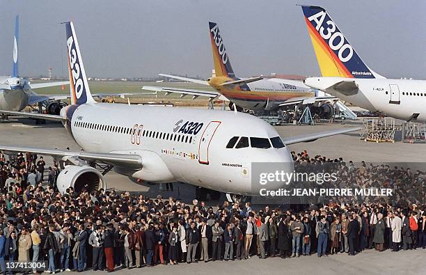 Employees of Aerospatiale pose near the new Airbus A320 airliner before its inaugural flight, 22 February 1987. The Airbus A320 airliner, a...