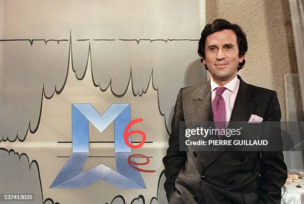 President Jean Drucker poses in front of the logo of Métropole 6, known as simply M6, during the launching of the new french private television...