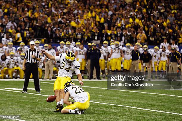 Brendan Gibbons of the Michigan Wolverines kicks a successful 37-yard game-winning field goal attempt in overtime from the hold of Drew Dileo against...