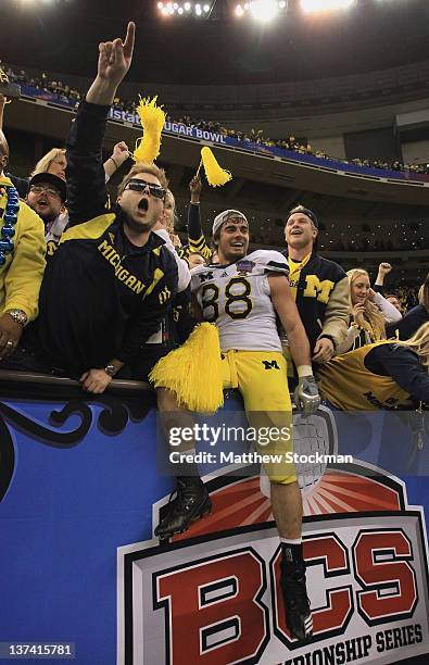 Craig Roh of the Michigan Wolverines celebrates with fans and students after Michigan won 23-20 in overtime against the Virginia Tech Hokies during...