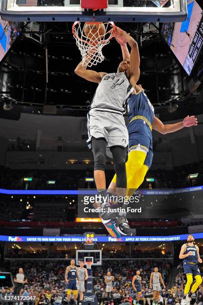 Devin Vassell of the San Antonio Spurs dunks against Desmond Bane of the Memphis Grizzlies during the second half at FedExForum on February 28, 2022...