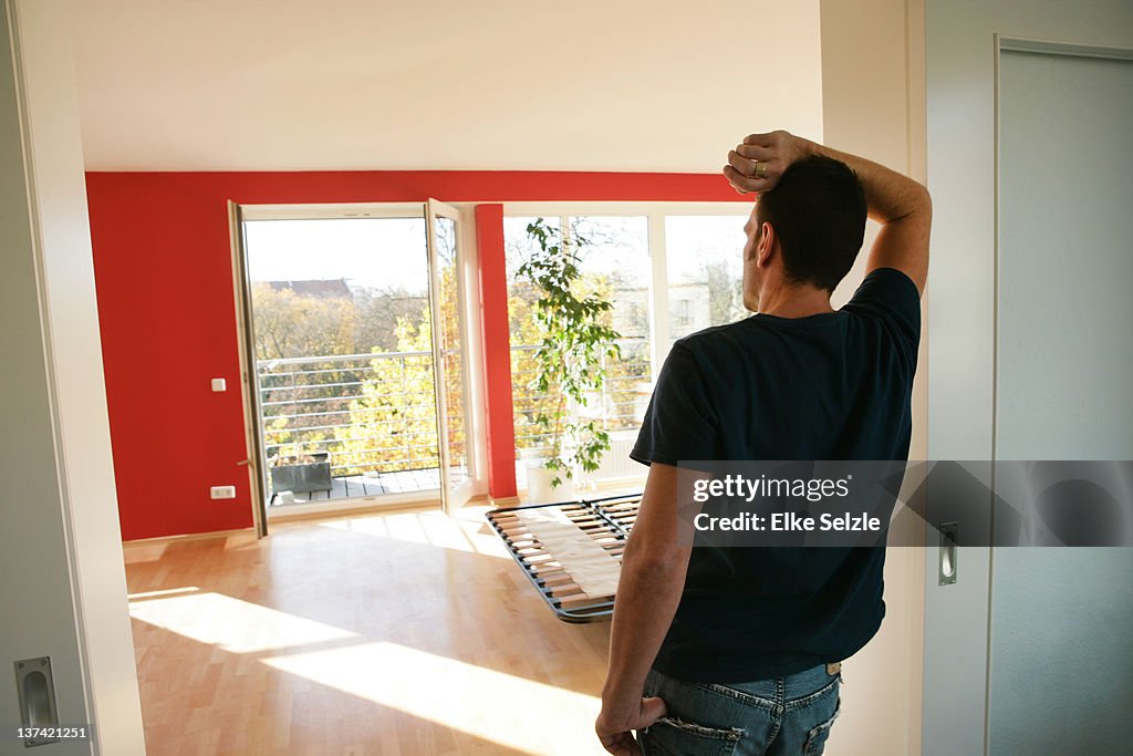 Close-up man in laying in empty apartment phoning