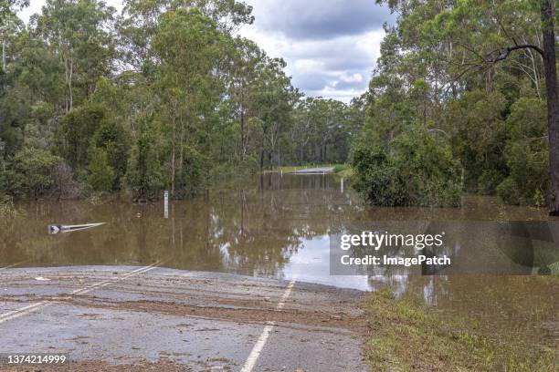 road closed - flooded regional arterial road blocked off  from passage - queensland floods stockfoto's en -beelden