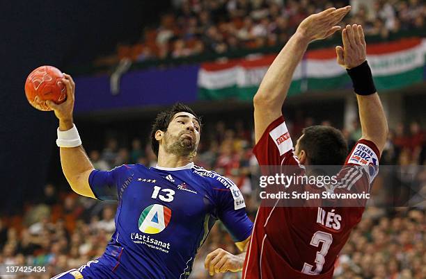 Nikola Karabatic of France shoots the ball past Ferenc Ilyes of Hungary during the Men's European Handball Championship 2012 group C match between...