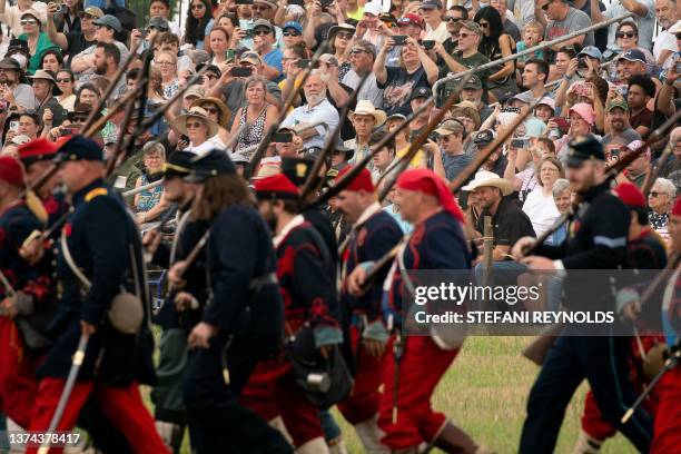 Spectators watch reenactors during the 160th reenactment of the Battle of Gettysburg, at Daniel Lady Farm in Gettysburg, Pennsylvania, on June 30,...