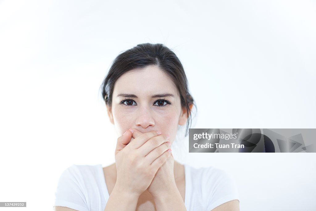 Woman with hands covering over her mouth