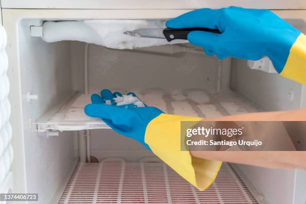 removing ice from a domestic freezer - frys bildbanksfoton och bilder