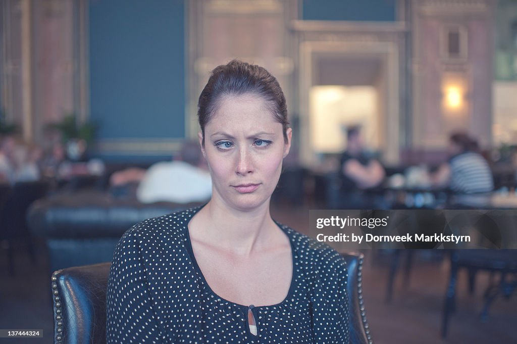 Woman in European cafe, crossed eyes