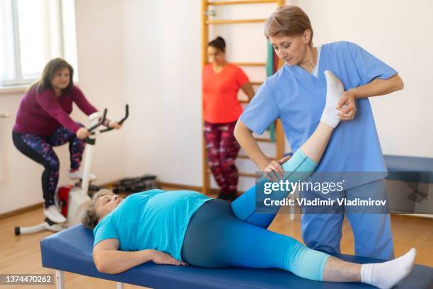 woman receiving some physical therapy from the healthcare worker - obesity imagens e fotografias de stock