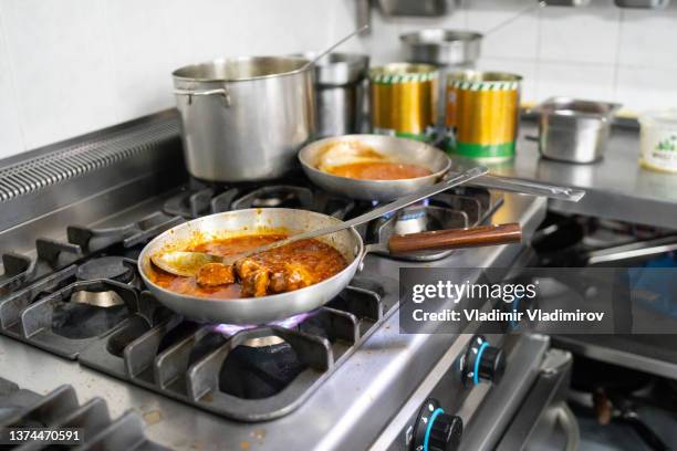 close up of a frying pan cooking food on a stove - chicken tandoori stock pictures, royalty-free photos & images
