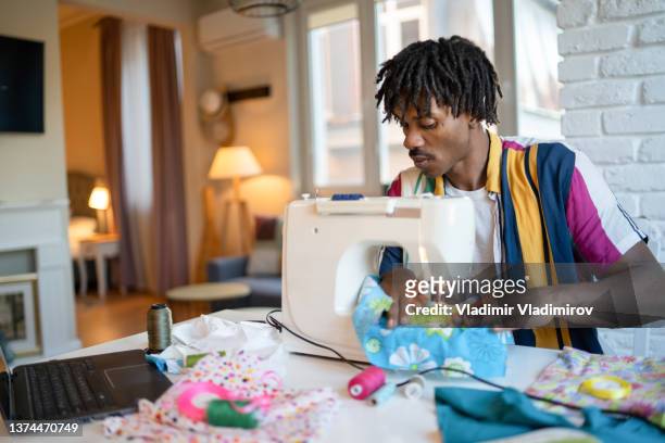 man using sewing machine at home - sewing machine imagens e fotografias de stock