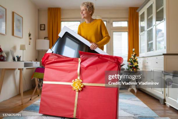 frau erhält zu weihnachten einen riesigen fernseher - gross domestic product stock-fotos und bilder