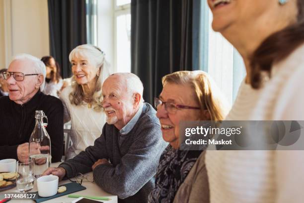 happy elderly men and women looking away at retirement home - aging happy stockfoto's en -beelden