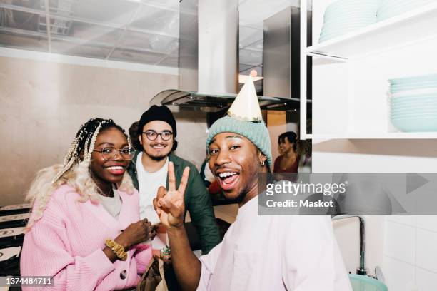 portrait of cheerful multiracial male and female students in kitchen at college dorm - college dorm party stock-fotos und bilder
