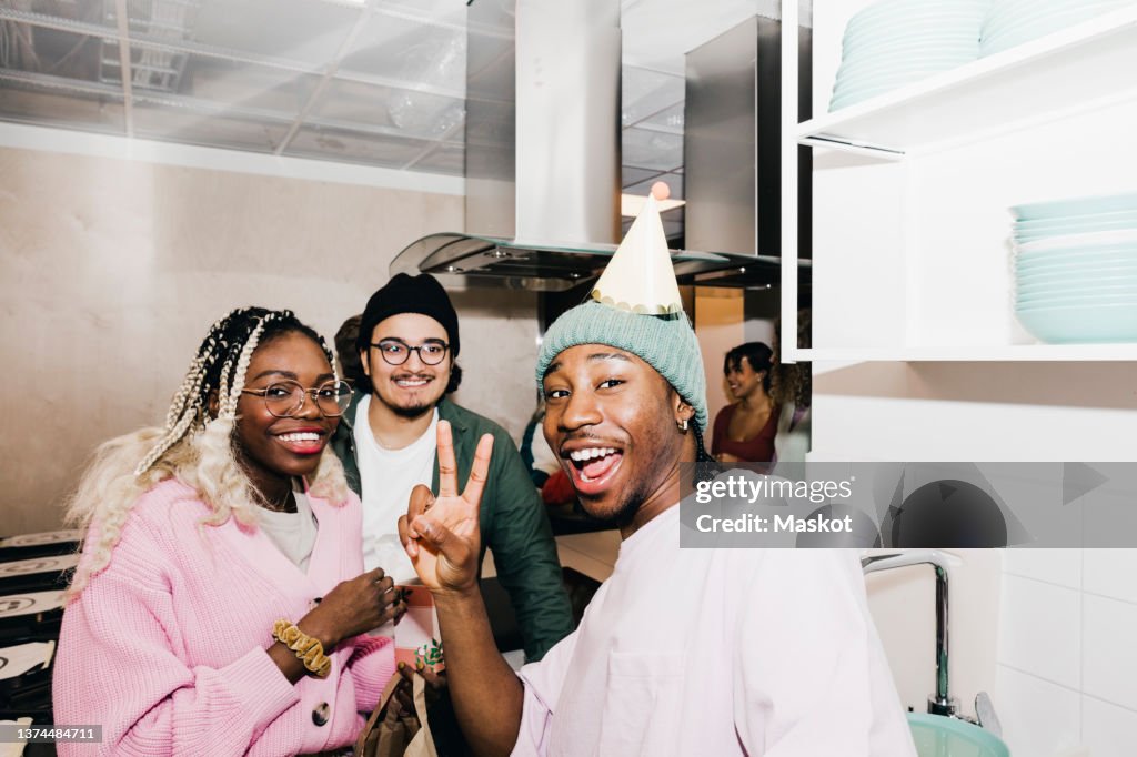 Portrait of cheerful multiracial male and female students in kitchen at college dorm