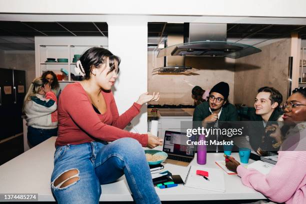 young woman talking with multiracial roommates in college dorm - dining table icon stock pictures, royalty-free photos & images