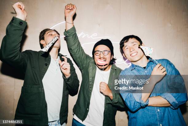 carefree multiracial male friends with props enjoying in college dorm - college dorm party stock pictures, royalty-free photos & images