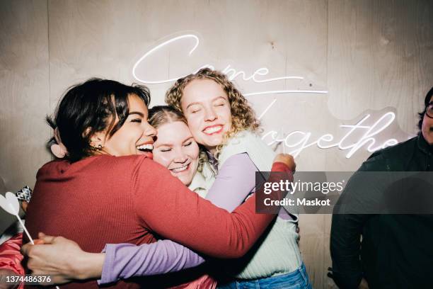 happy multiracial female friends embracing each other in college dorm - unileben stock-fotos und bilder