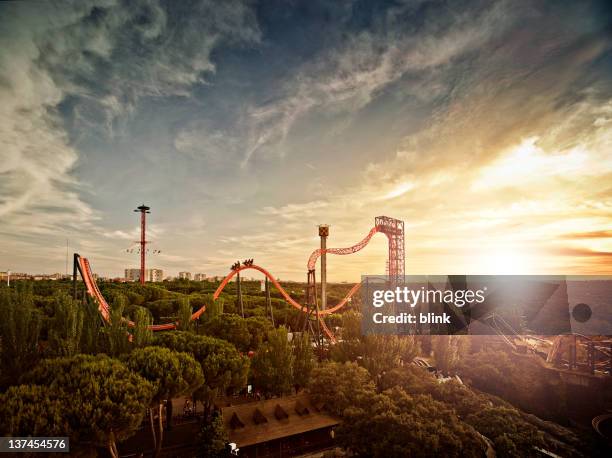 silhouette of roller coaster at sunset - achterbahn stock-fotos und bilder