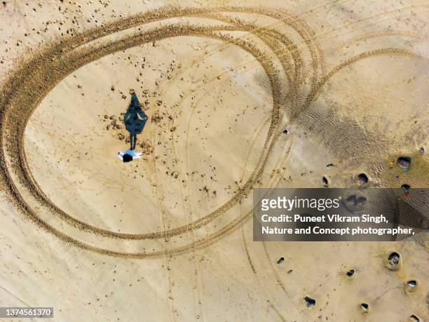 an indian girl dancing at the beach in an abstract drone shot - politics and government stock pictures, royalty-free photos & images