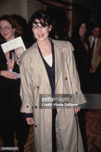 American actress Lara Flynn Boyle, wearing a tan raincoat, attends the Westwood premiere of 'Wayne's World,' held at Mann's Village Theater in Los...