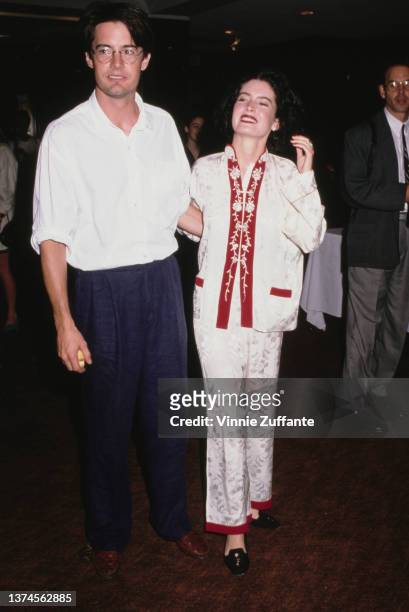 American actor Kyle MacLachlan, wearing a white shirt with the sleeves rolled up and blue trousers, and his partner, American actress Lara Flynn...