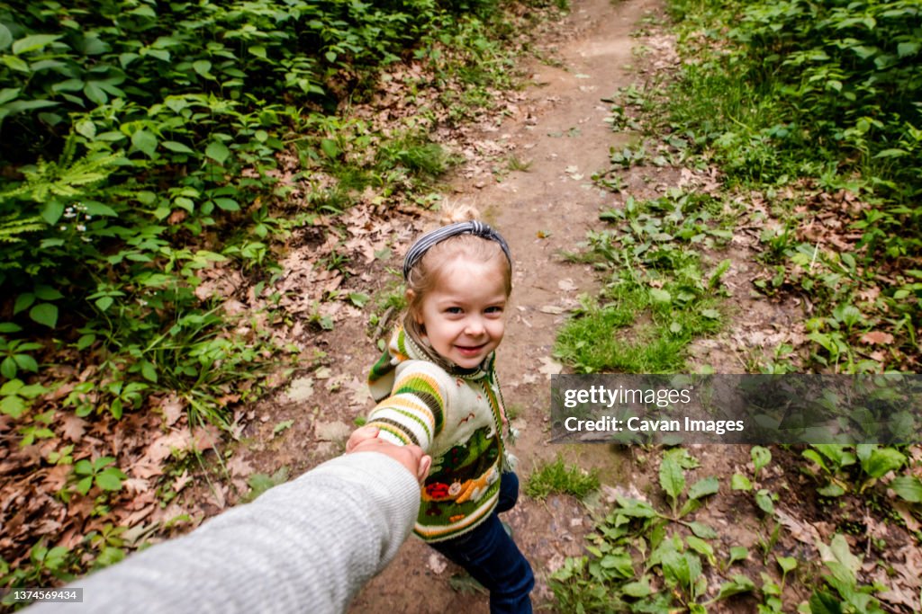 Girl pulling mom in the woods on a hike