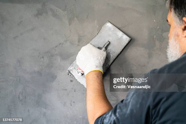 close up of human hands working on concrete wall texture - spatel stockfoto's en -beelden