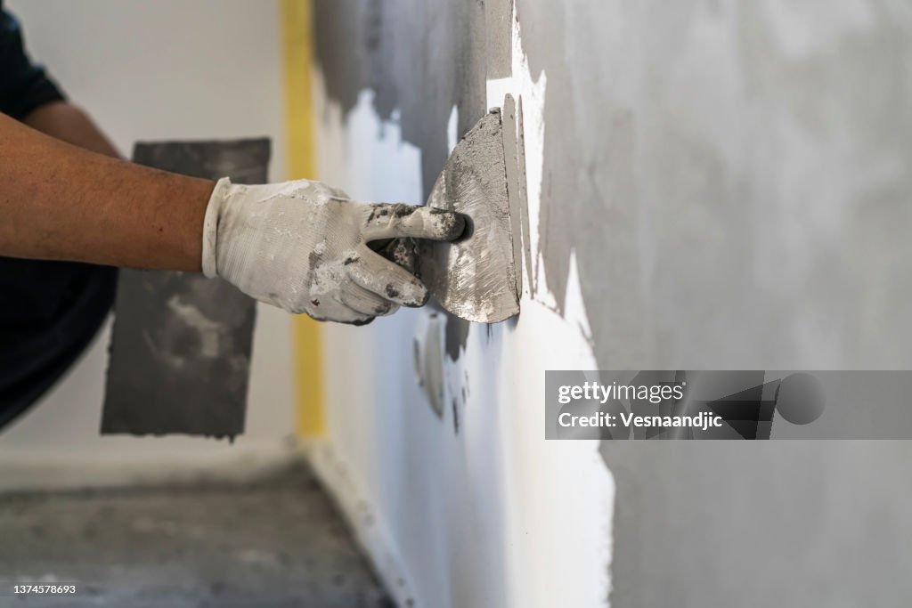 Close up of human hands working on concrete wall texture
