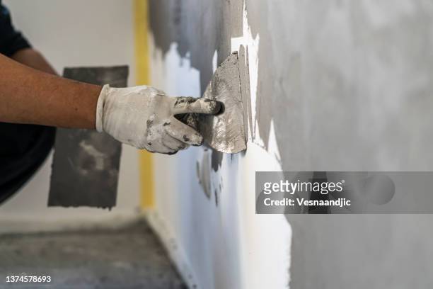 close up of human hands working on concrete wall texture - gips bouwmateriaal stockfoto's en -beelden