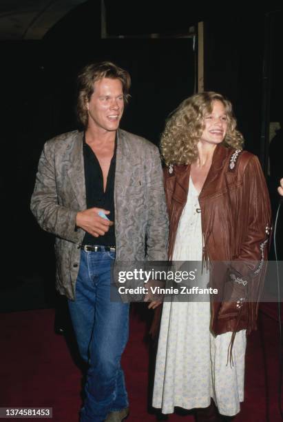 American actor Kevin Bacon and his wife, American actress Kyra Sedgwick attend the Hollywood premiere of 'Ghostbusters II,' held at the Mann's...