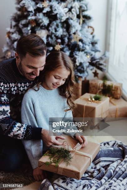 christmas morning father and daughter opening a present - papa noel stockfoto's en -beelden